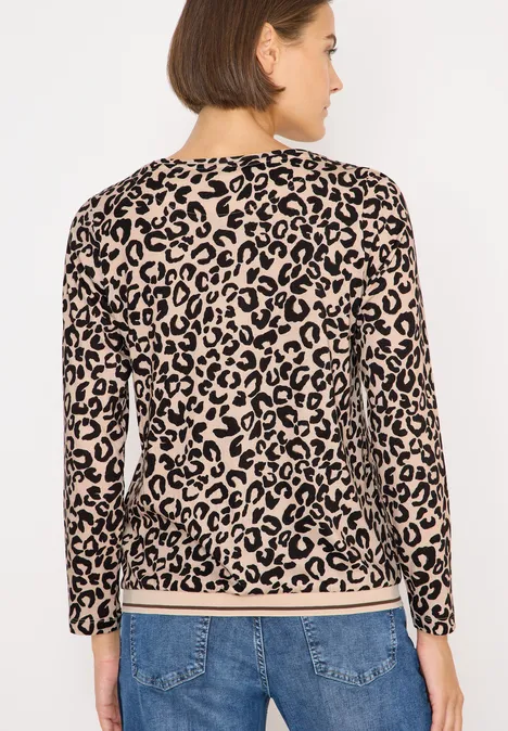 Frau mit Leopardenmuster-Pullover und Jeans, von hinten fotografiert.